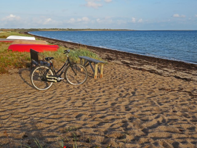 Fahrrad lehnt an einer Bank am Ostseestrand