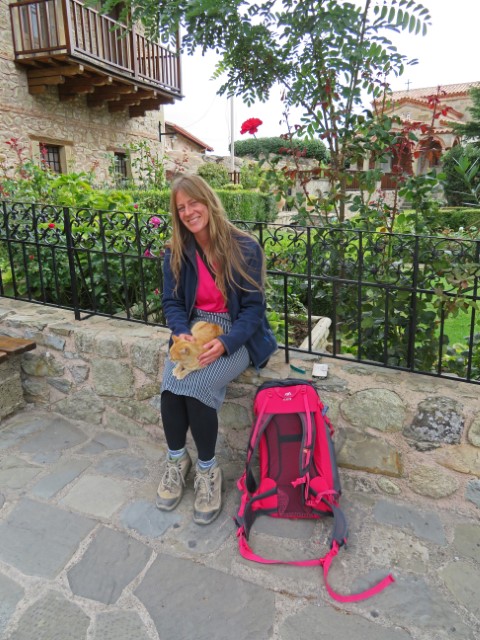 Junge Frau mit Rock und Katze auf dem Schoß im Klostergarten