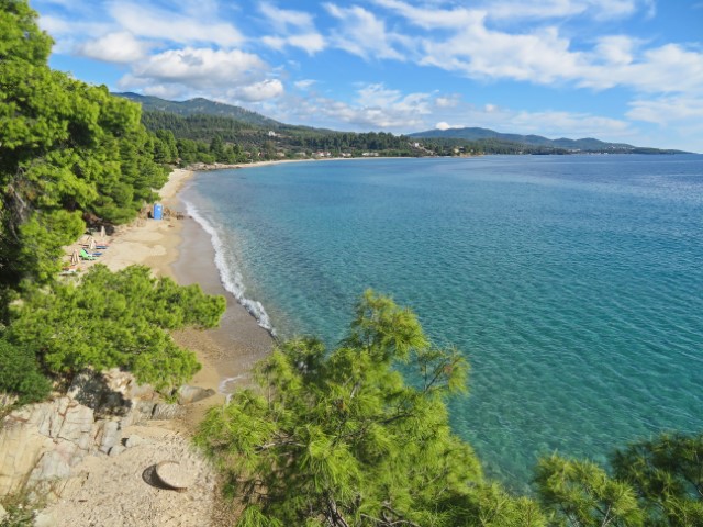 Kalogria Strand mit hellem Sand, Bäumen und blauem Meer