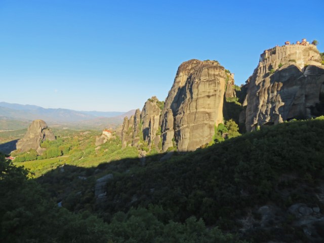 Klippen mit den Meteora-Klöstern darauf im frühen Sonnenlicht