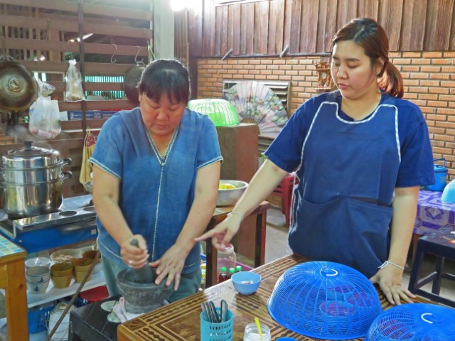 Zwei Thai Frauen am Tisch bereiten ein Essen zu