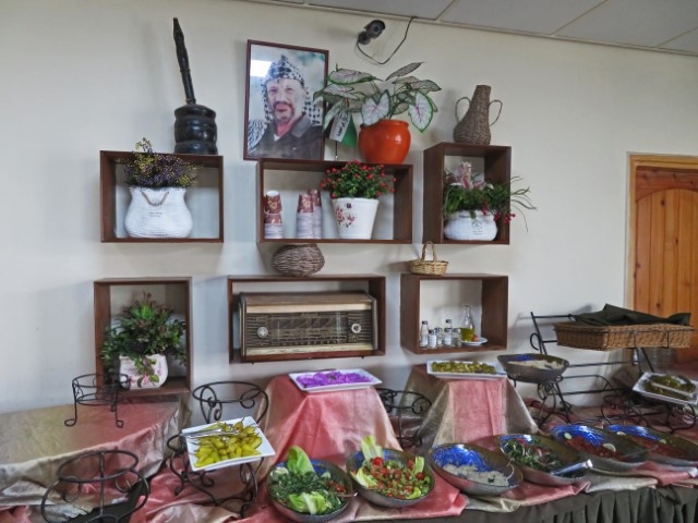 Salatbuffet in einem Nablus-Restaurant mit Bild von Arafat und historischen Objekten darüber