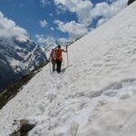 Zwei Wanderer stapßfen auf dem Ortler Höhenweg an einem verschneiten Abhang entlang