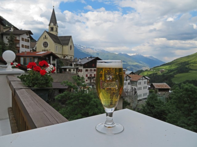 Bier vor der Kulisse der Dorfhäuser und Berge in Stilfs