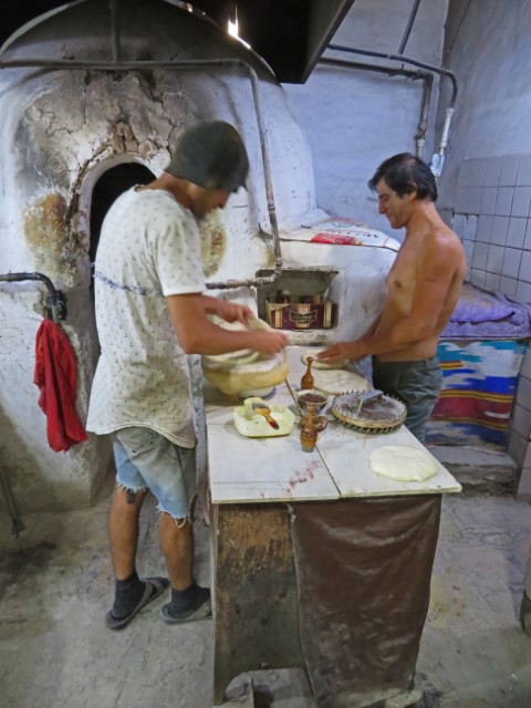 Zwei junge Männer backen an einem Ofen Pide