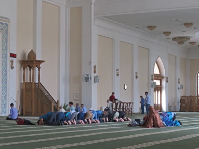 Männer beten mit zum Boden geneigten Kopf in der Hazrat Iman Moschee in Tashkent.