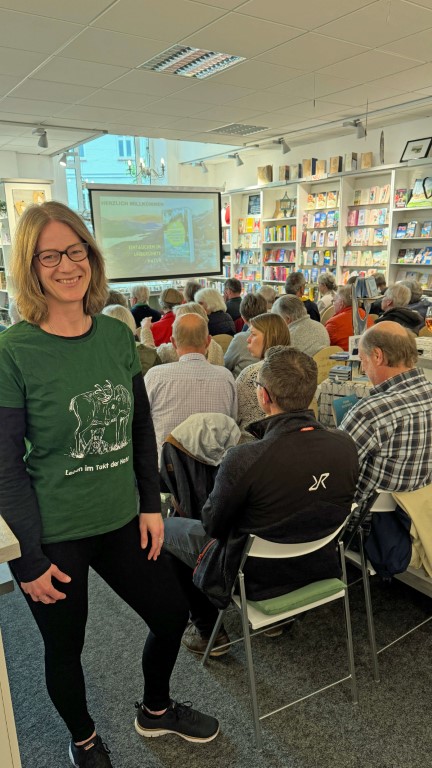 Autorin Bernadette Olderdissen steht hinter ihrem Publikum in einer Buchhandlung