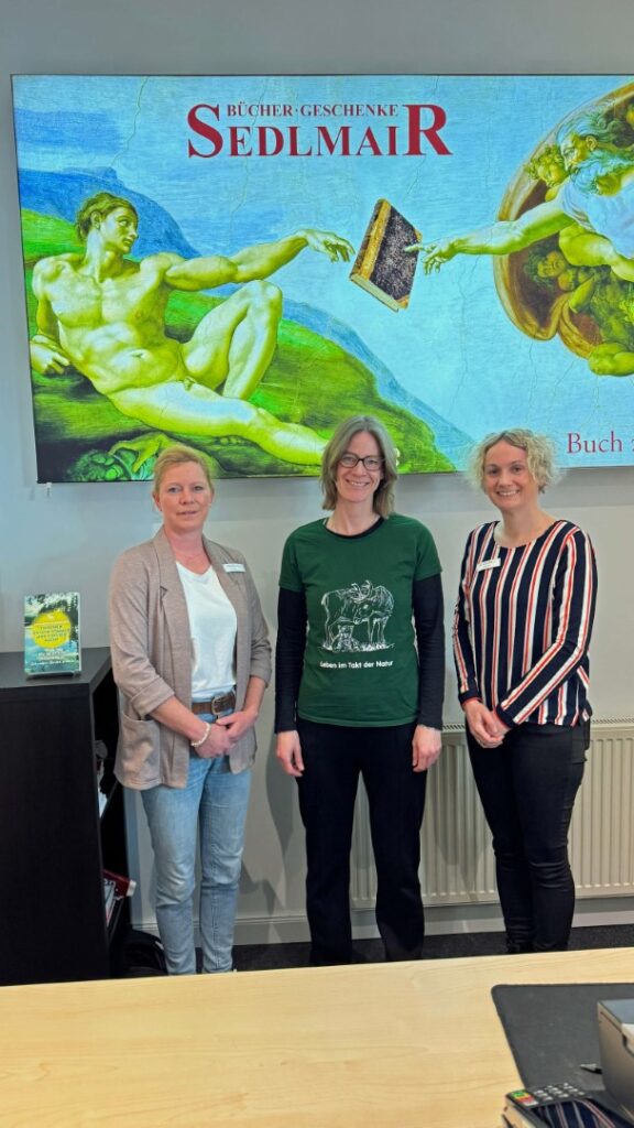 Autorin Bernadette Olderdissen zwischen zwei Buchladen-Mitarbeiterinnen